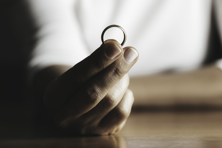 Hands of caucasian female who is about to taking off her wedding ring.